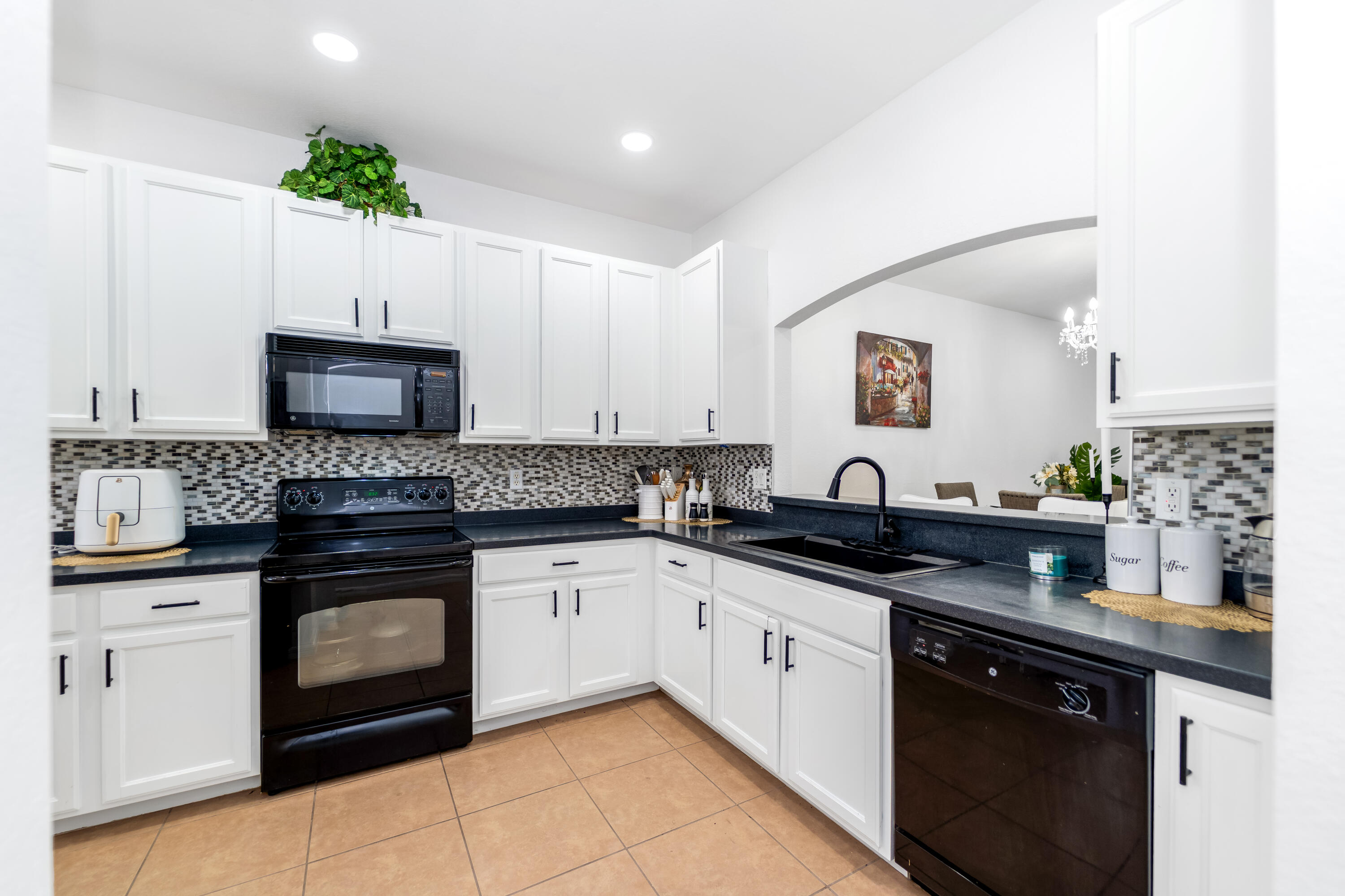 14190 Fall Creek Court Naples, FL 34114 - Photo 10 of 25 a kitchen with a sink stove and microwave