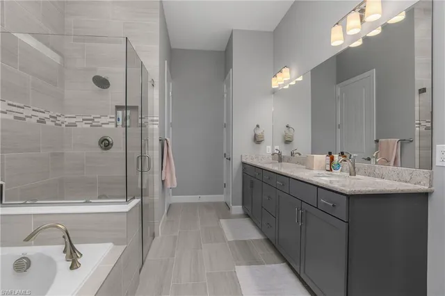 a bathroom with a double vanity sink a large mirror and shower