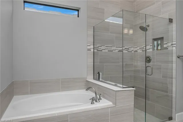 a white bath tub sitting next to a shower