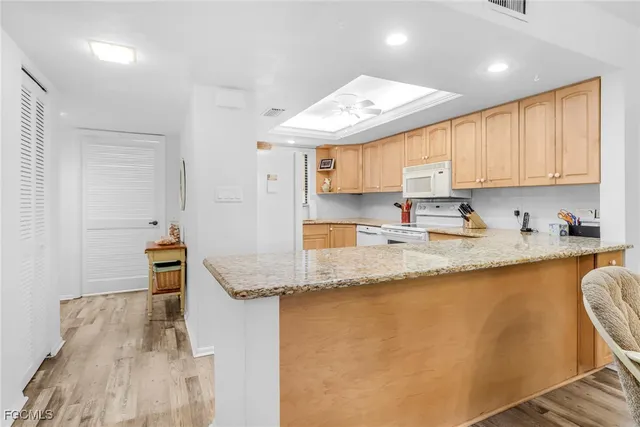 a kitchen with stainless steel appliances granite countertop a sink a stove and cabinets