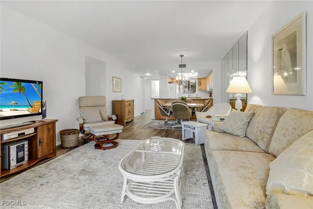 a living room with furniture a chandelier and a flat screen tv
