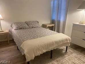 a bed sitting in a bedroom and wooden floor