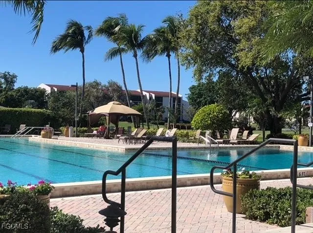a view of swimming pool with table and chairs under an umbrella