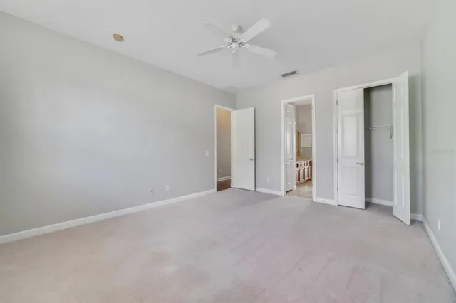an empty room with a ceiling fan and a window