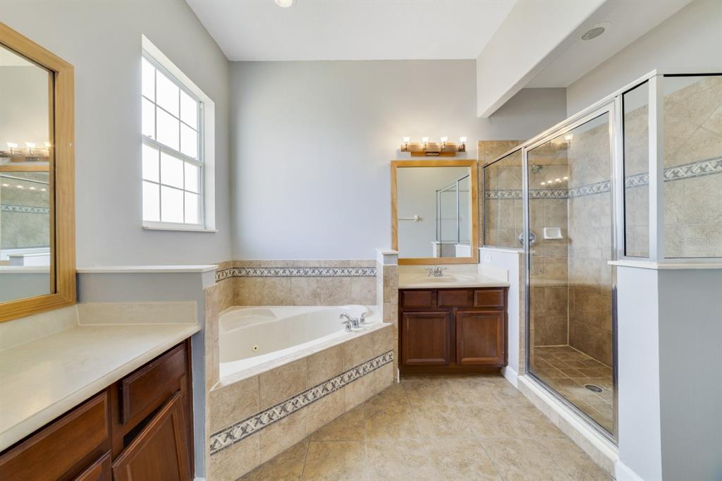 1426 Fairview Circle Reunion, FL 34747 - Photo 28 of 35 a spacious bathroom with a tub sink shower and mirror