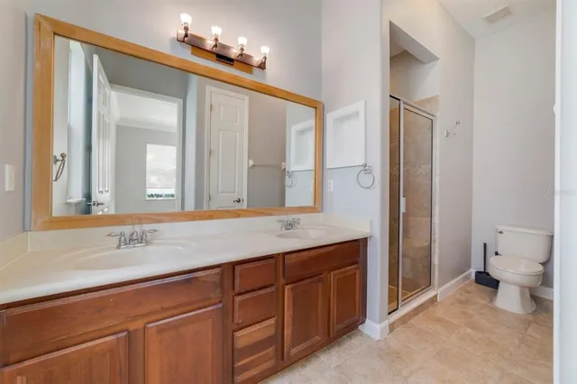 a bathroom with a granite countertop sink a toilet and a mirror