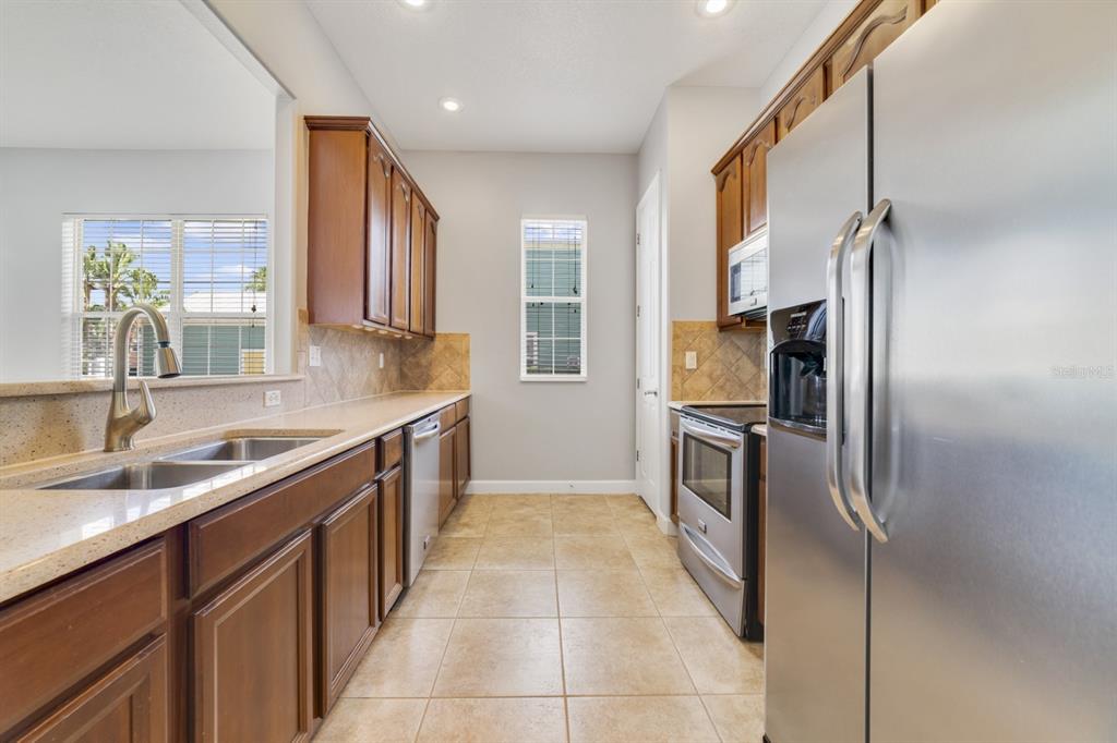 1426 Fairview Circle Reunion, FL 34747 - Photo 8 of 35 a kitchen with stainless steel appliances granite countertop a sink stove and refrigerator