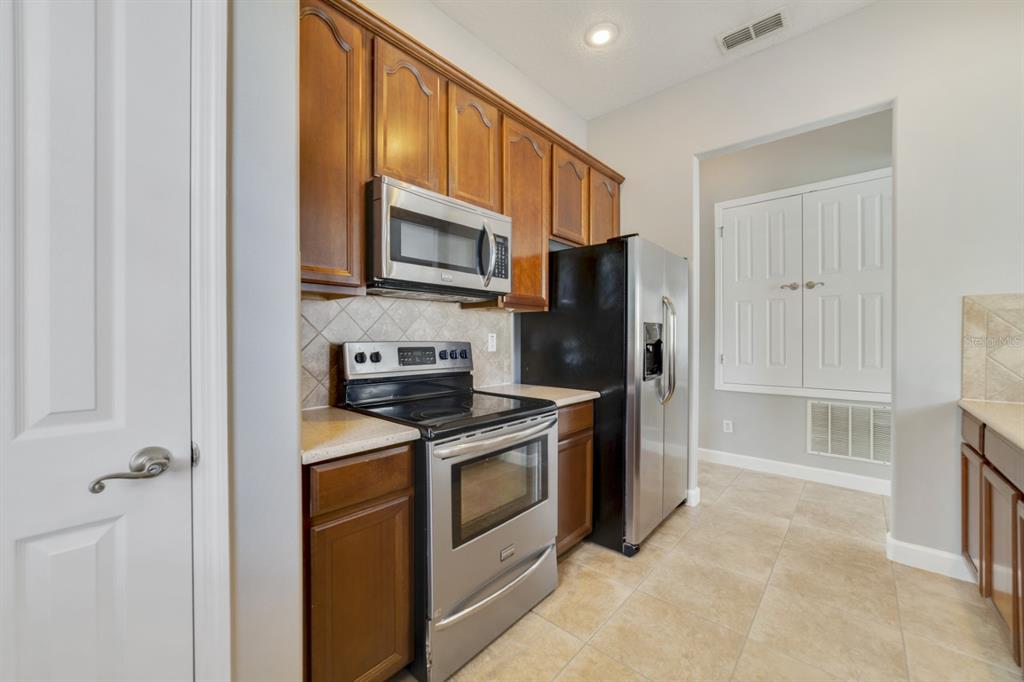1426 Fairview Circle Reunion, FL 34747 - Photo 10 of 35 a kitchen with stainless steel appliances granite countertop a stove a refrigerator and a microwave