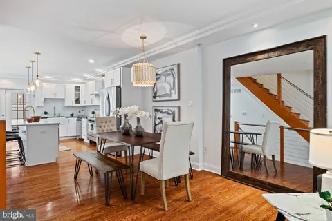 a view of a dining room with furniture a rug and wooden floor