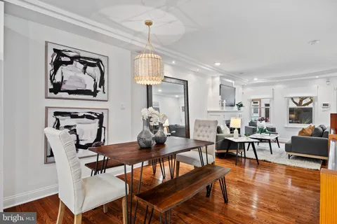 a kitchen with stainless steel appliances granite countertop a refrigerator a stove top oven a sink dishwasher and white cabinets with wooden floor