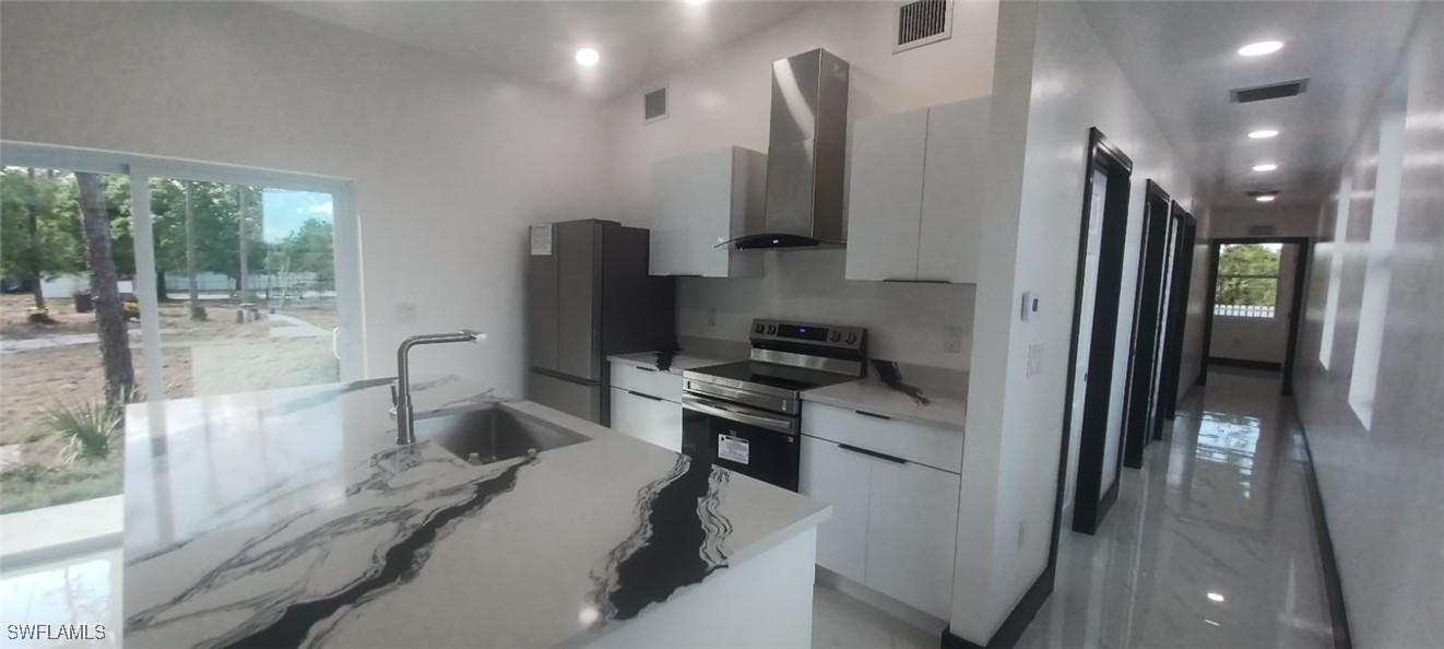 810 South Cabbage Palm Street Clewiston, FL 33440 - Photo 13 of 32 a kitchen with stainless steel appliances a refrigerator sink and stove