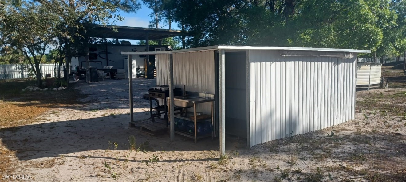 810 South Cabbage Palm Street Clewiston, FL 33440 - Photo 24 of 32 a side view of a house with backyard and sitting area