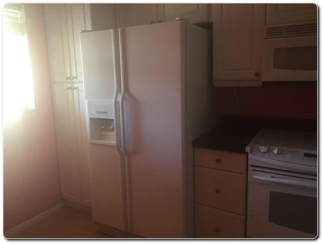 2805 Southwest 22nd Avenue, Unit 2060 Delray Beach, FL 33445 - Photo 3 of 7 a kitchen with a refrigerator and cabinets