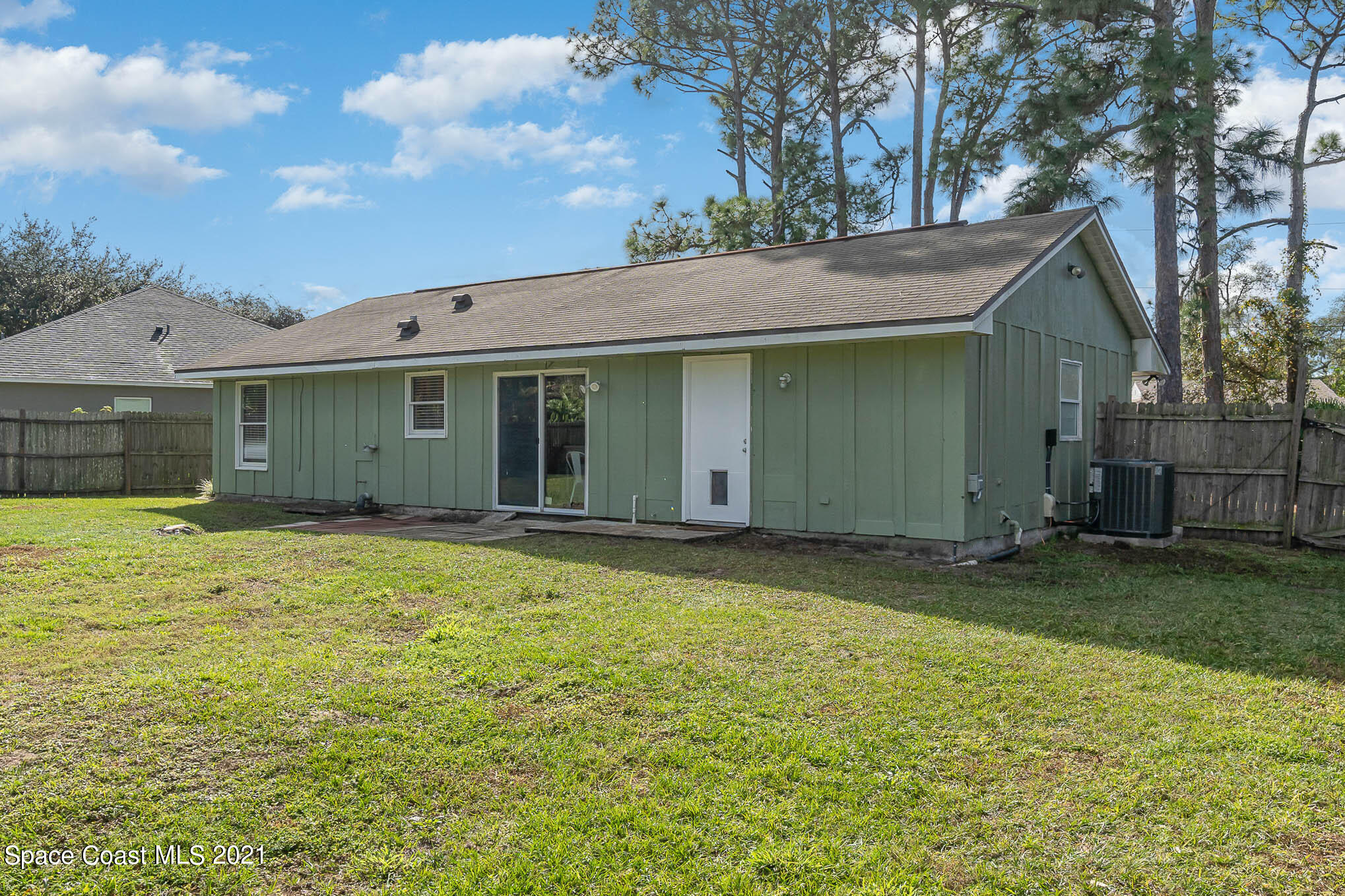 6921 Bentley Road Cocoa, FL 32927 - Photo 23 of 26 a view of a house with a backyard and a tree