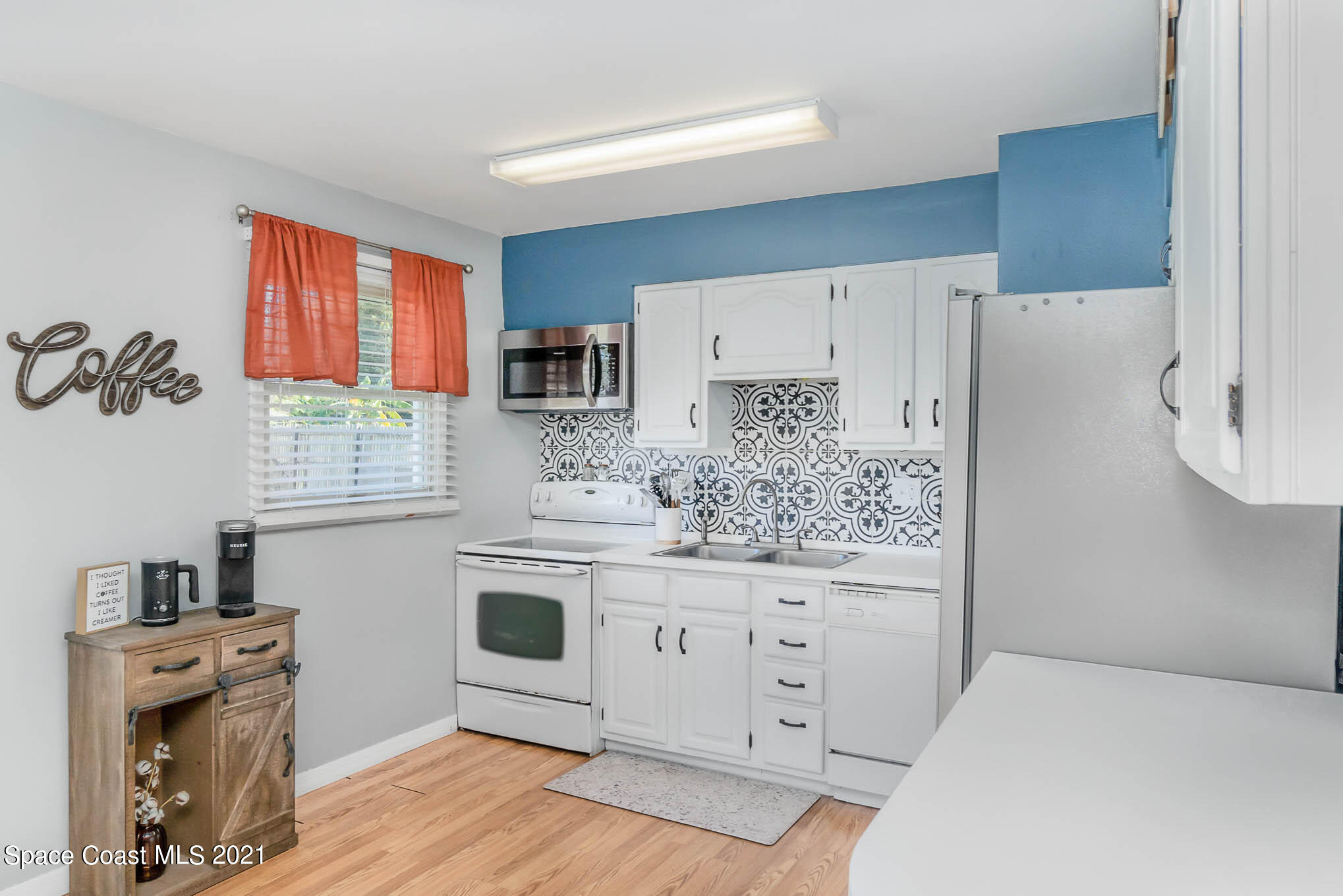 6921 Bentley Road Cocoa, FL 32927 - Photo 10 of 26 a kitchen with stainless steel appliances white cabinets and a window