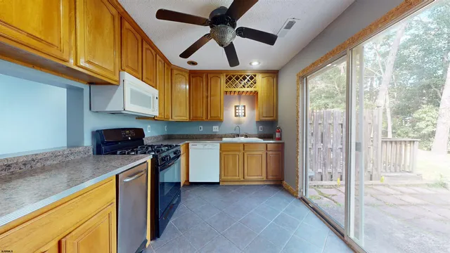 a kitchen with stainless steel appliances granite countertop sink stove and refrigerator