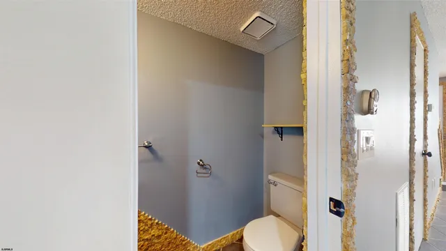 a bathroom with a granite countertop toilet and a shower