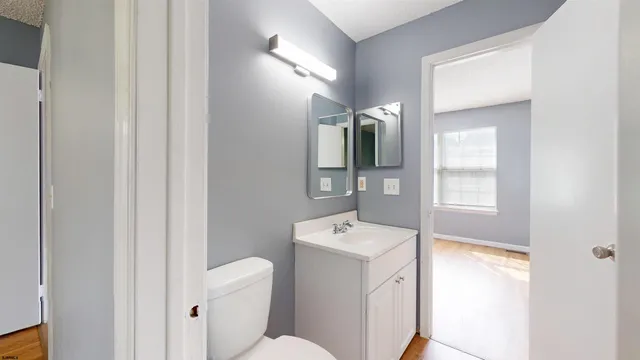 a bathroom with a toilet sink and mirror