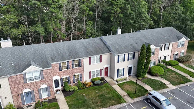 a aerial view of a brick house next to a yard