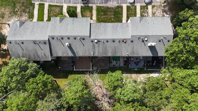 an aerial view of a house with a yard and large trees