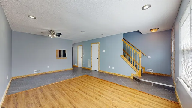 a view of an empty room with stairs and a window