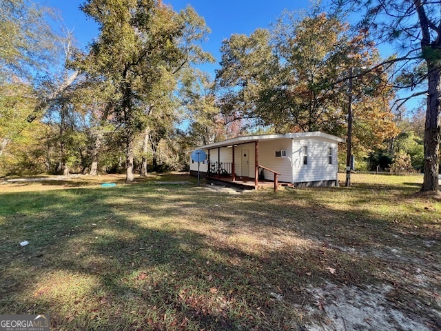 3195 Henderson Grove Road Sandersville, GA 31082 - Photo 19 of 50 a view of a white house with a big yard and large trees