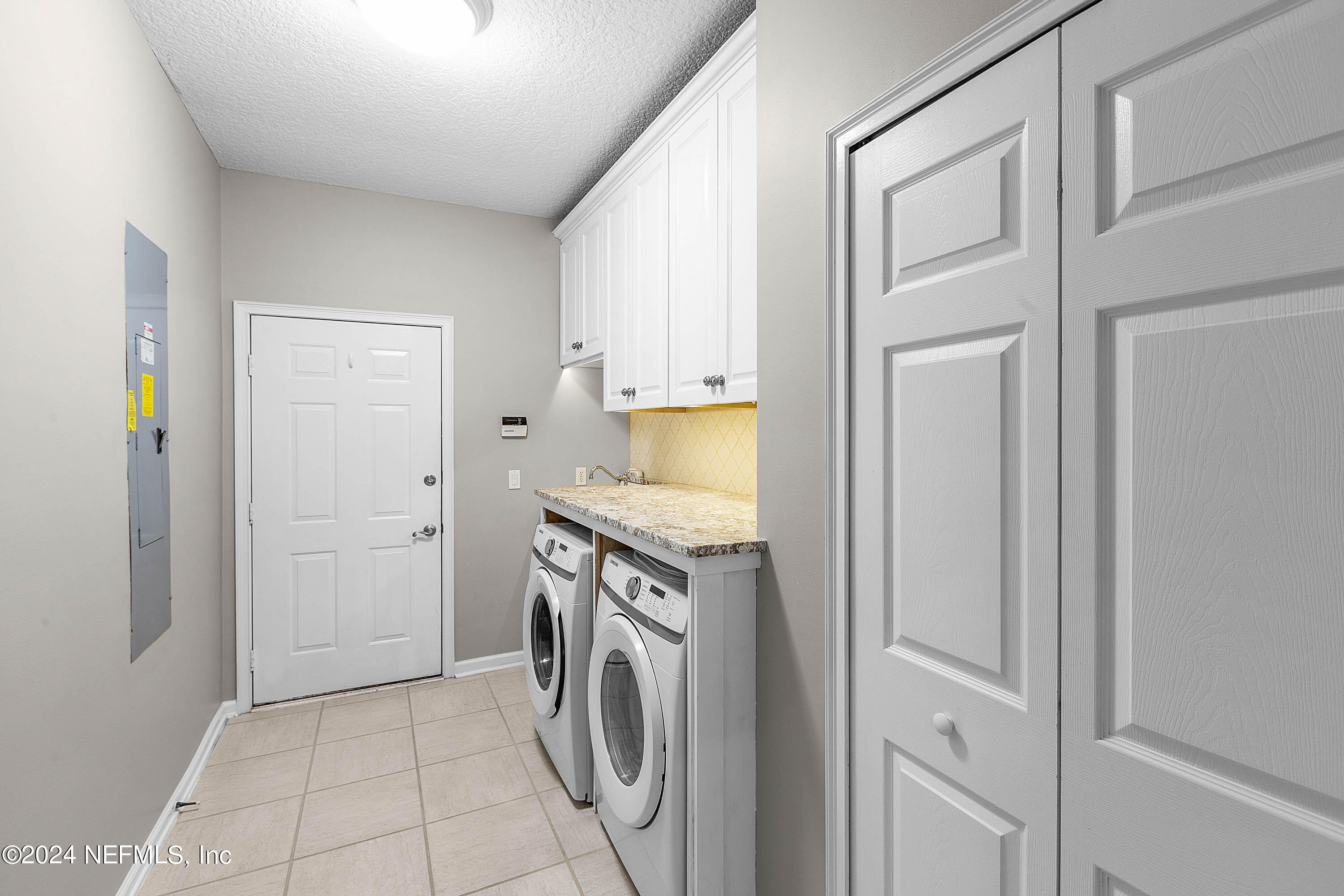 9975 Vineyard Lake Road East Jacksonville, FL 32256 - Photo 28 of 57 a utility room with cabinets washer and dryer