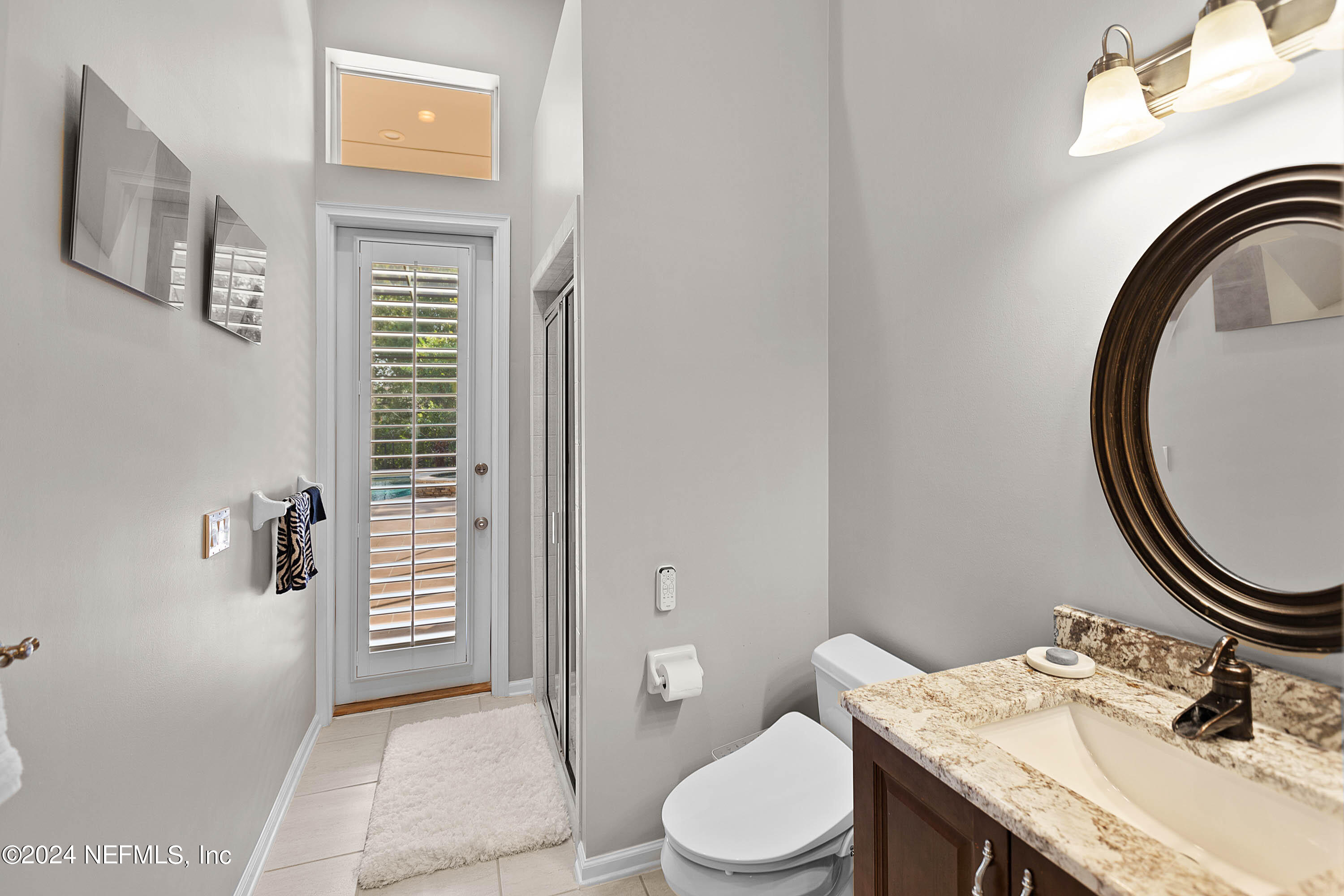 9975 Vineyard Lake Road East Jacksonville, FL 32256 - Photo 8 of 57 a bathroom with a granite countertop toilet a sink and a mirror