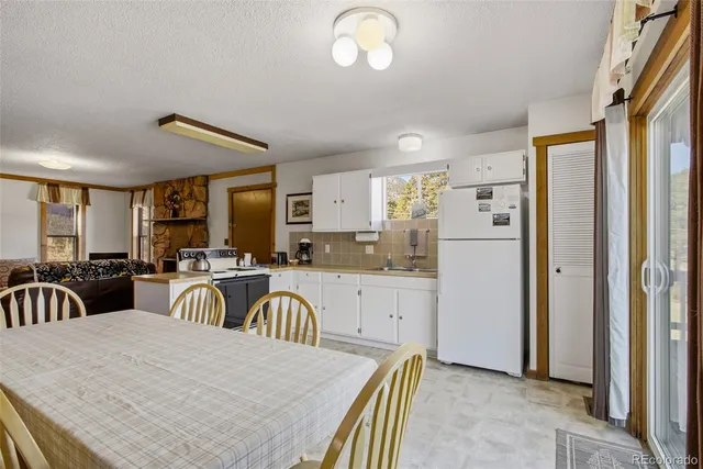a kitchen with sink refrigerator dining table and chairs