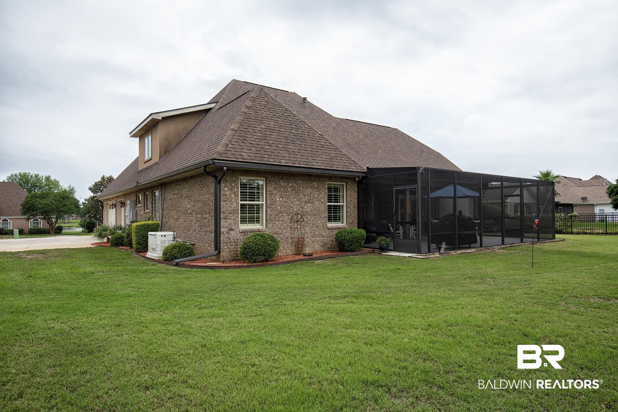 9357 Lakeview Drive Foley, AL 36535 - Photo 18 of 68 Brick exterior featuring a screened patio enclosure, dormer window, and dark shingle roof