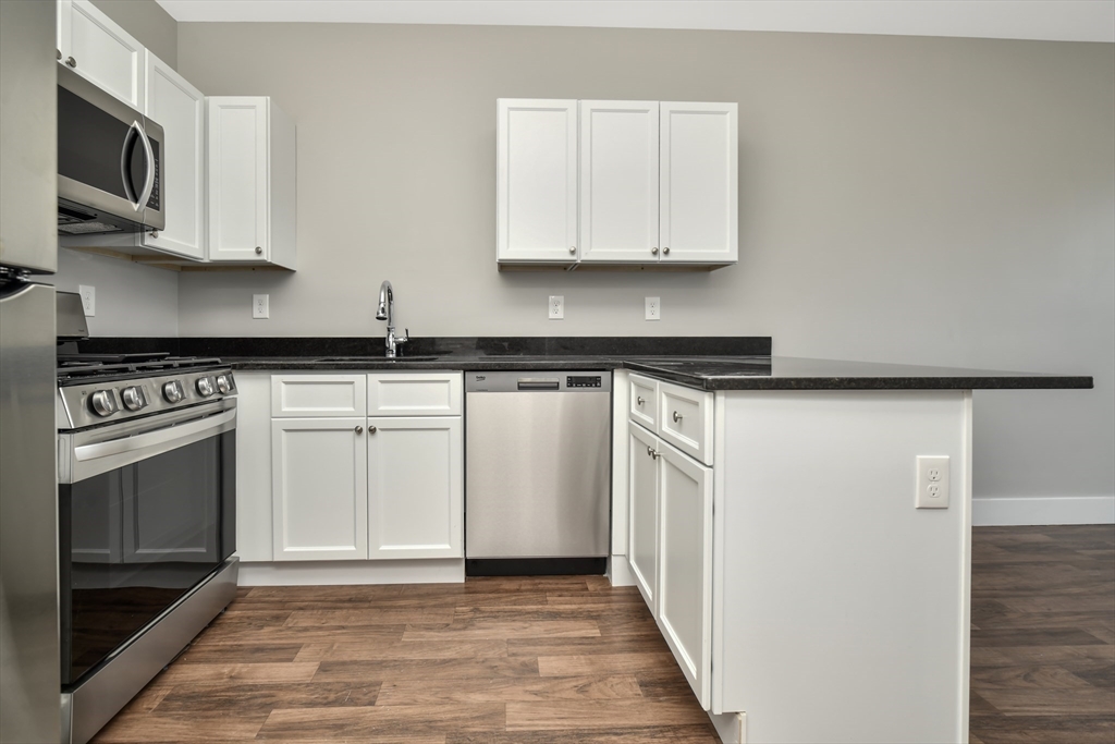 1903 Columbus Avenue Boston, MA 02119 - Photo 3 of 11 a kitchen with stainless steel appliances granite countertop a stove a sink and a microwave
