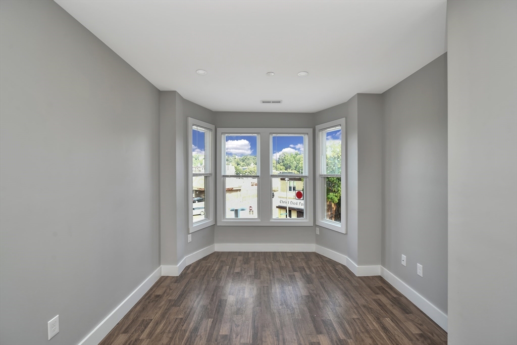 1903 Columbus Avenue Boston, MA 02119 - Photo 5 of 11 wooden floor in an empty room with a window