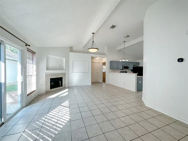 a view of a electric appliances in kitchen and empty room with wooden floor