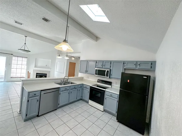 a kitchen with stainless steel appliances granite countertop a stove sink and refrigerator