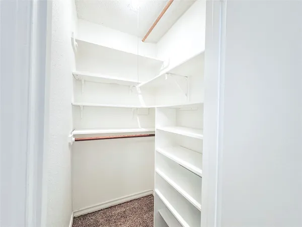 a view of walk in closet with empty racks