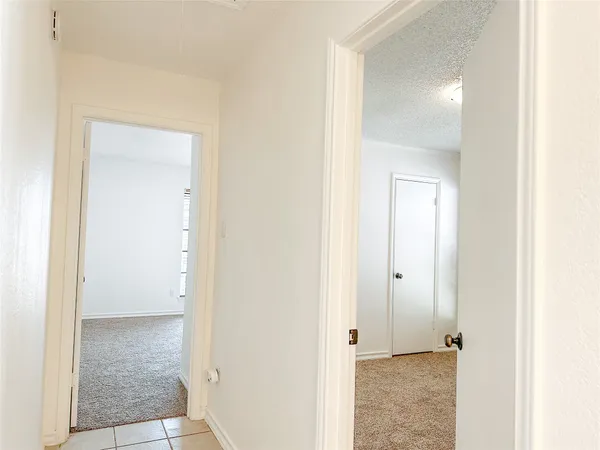 a view of a hallway with closet and a bathroom