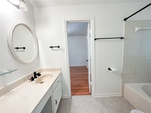 a bathroom with a tub sink and mirror
