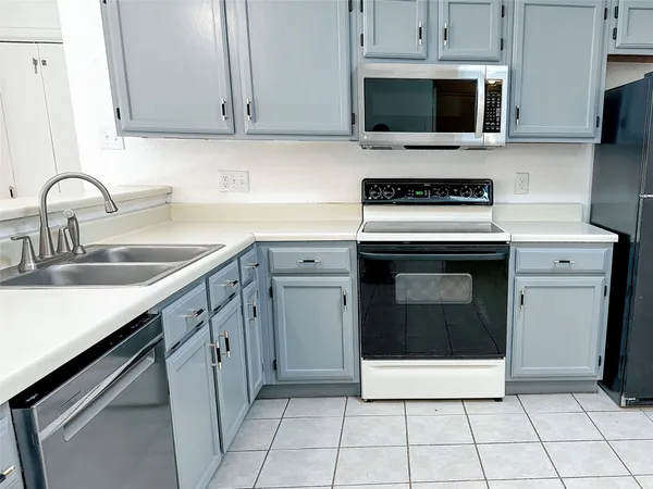 a kitchen with cabinets stainless steel appliances and a sink