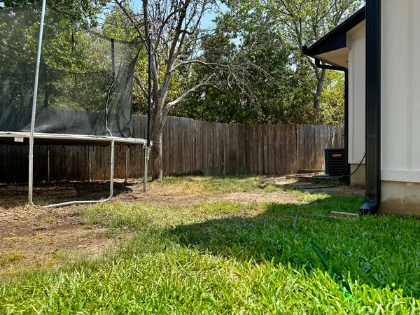 a view of a backyard with small cabin and wooden fence