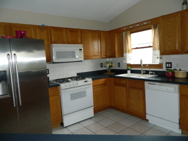 285 Rollin Road Somonauk, IL 60552 - Photo 8 of 25 a kitchen with stainless steel appliances granite countertop a sink stove and refrigerator