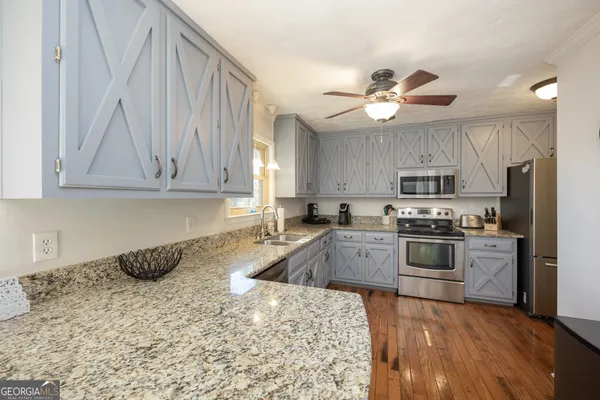 a kitchen with a sink stove top oven and cabinets