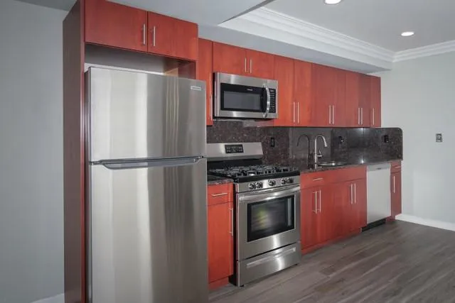 a kitchen with stainless steel appliances granite countertop a refrigerator stove and microwave