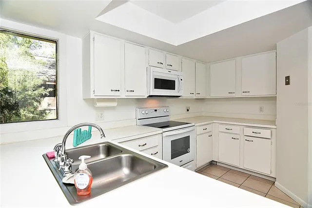 a kitchen with kitchen island a stove a sink and a microwave