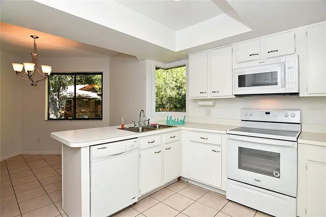 a kitchen with white cabinets appliances and sink