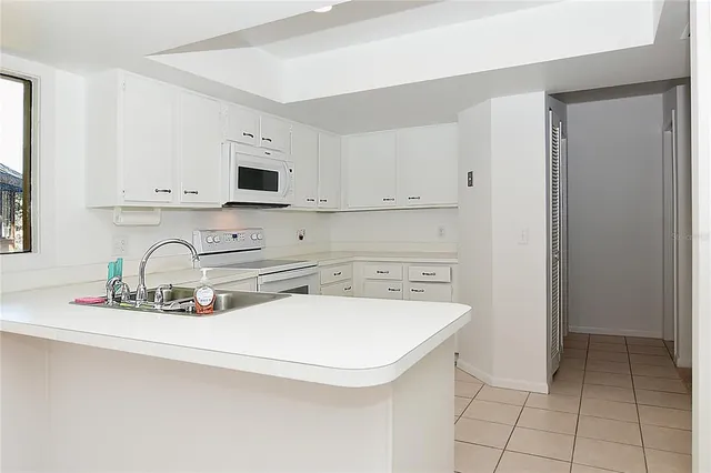 a kitchen with stainless steel appliances granite countertop a sink a stove and white cabinets