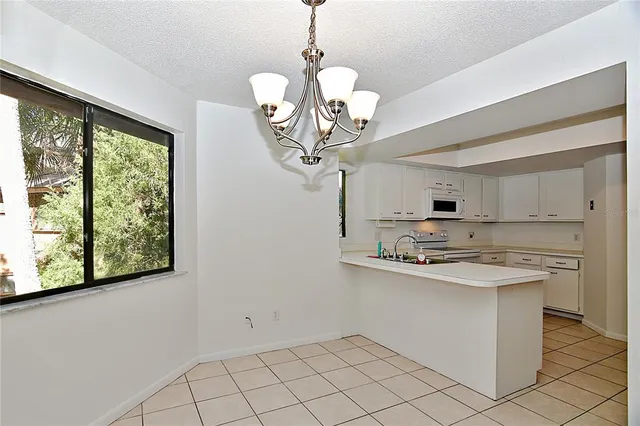 a kitchen with stainless steel appliances granite countertop a sink a stove a chimney a large mirror and cabinets