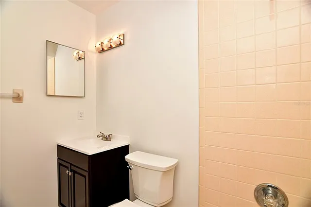 a bathroom with a toilet a sink and mirror