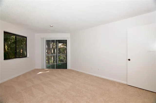 a view of an empty room with window and closet area