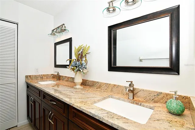 a bathroom with a granite countertop sink and a mirror