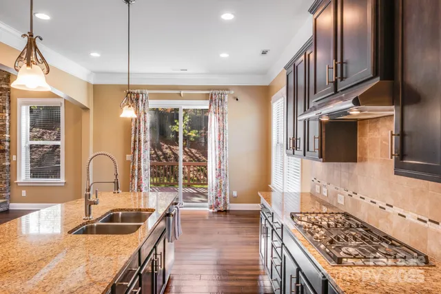 a kitchen with granite countertop a stove and a sink